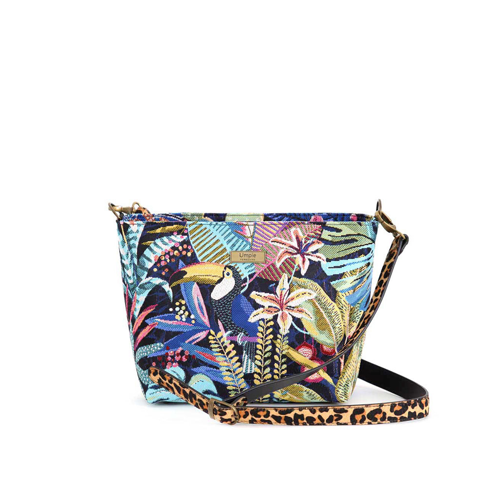 Front view of Tropical Tapestry Crossbody Bag on white background, richly woven toucan and jungle foliage tapestry on black with leopard print leather strap, by Umpie Handbags