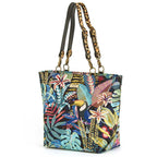 Angled front view of Tropical Toucan Shoulder Bag on white background, richly woven toucan and jungle foliage tapestry on navy with leopard print leather handles and antique gold hardware, by Umpie Handbags