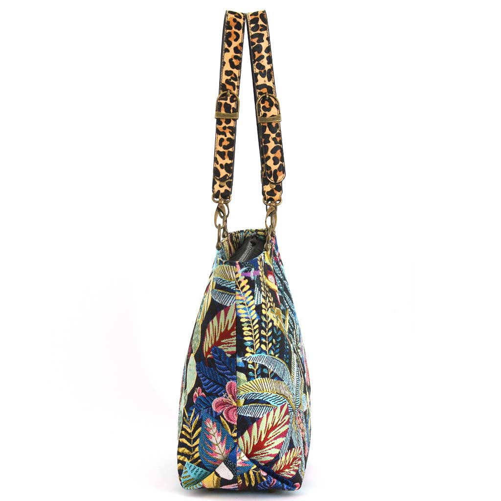 Side profile of Tropical Toucan Shoulder Bag on white background showing generous depth and structured silhouette, tropical tapestry fabric with bold leopard print leather handles, by Umpie Handbags