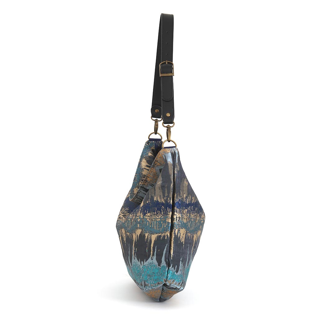 Side profile of Teal Metallic Hobo Bag displaying relaxed hobo silhouette and adjustable black leather strap by Umpie Handbags