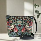 William Morris Crossbody Bag worn across body showing iconic Strawberry Thief tapestry design and black leather strap by Umpie Handbags