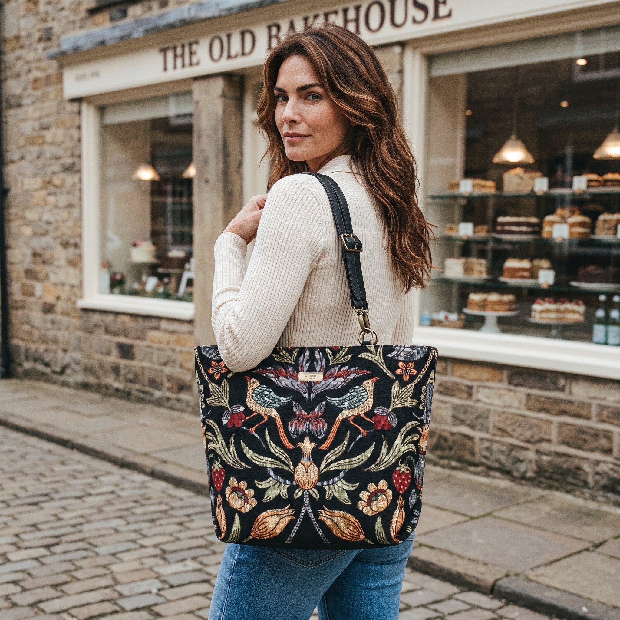 William Morris Shoulder Bag carried by model in a street in Yorkshire, showing Victorian botanical tapestry and black leather straps by Umpie Handbags