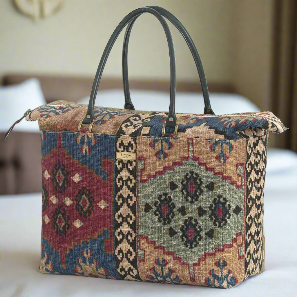 Front-facing canvas weekend bag displaying bold Kilim design with intricate geometric patterns, premium black leather handles, and sophisticated weekend travel styling by Umpie Handbags